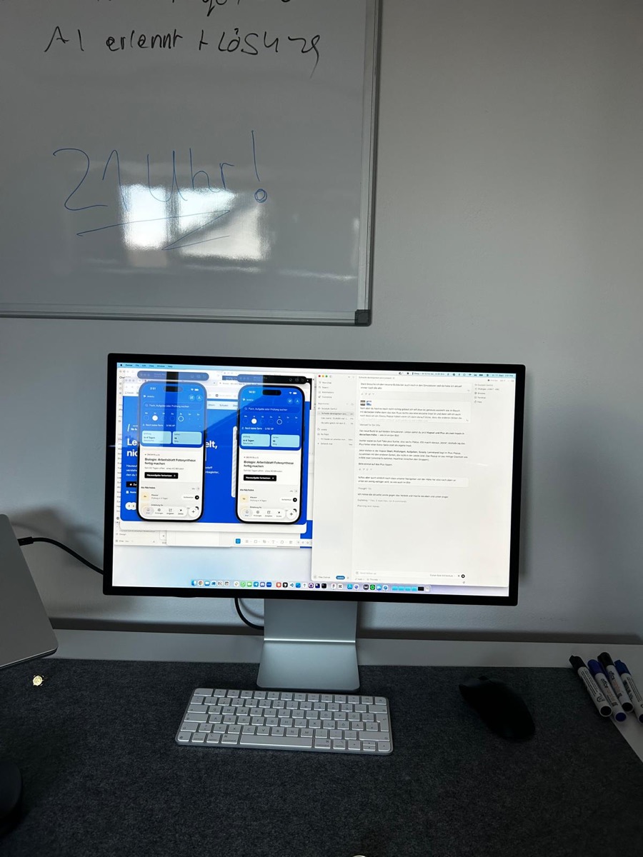 Studio Display mit zwei Entw&uuml;rfen der Scooly-App, daneben ein Whiteboard mit Notizen